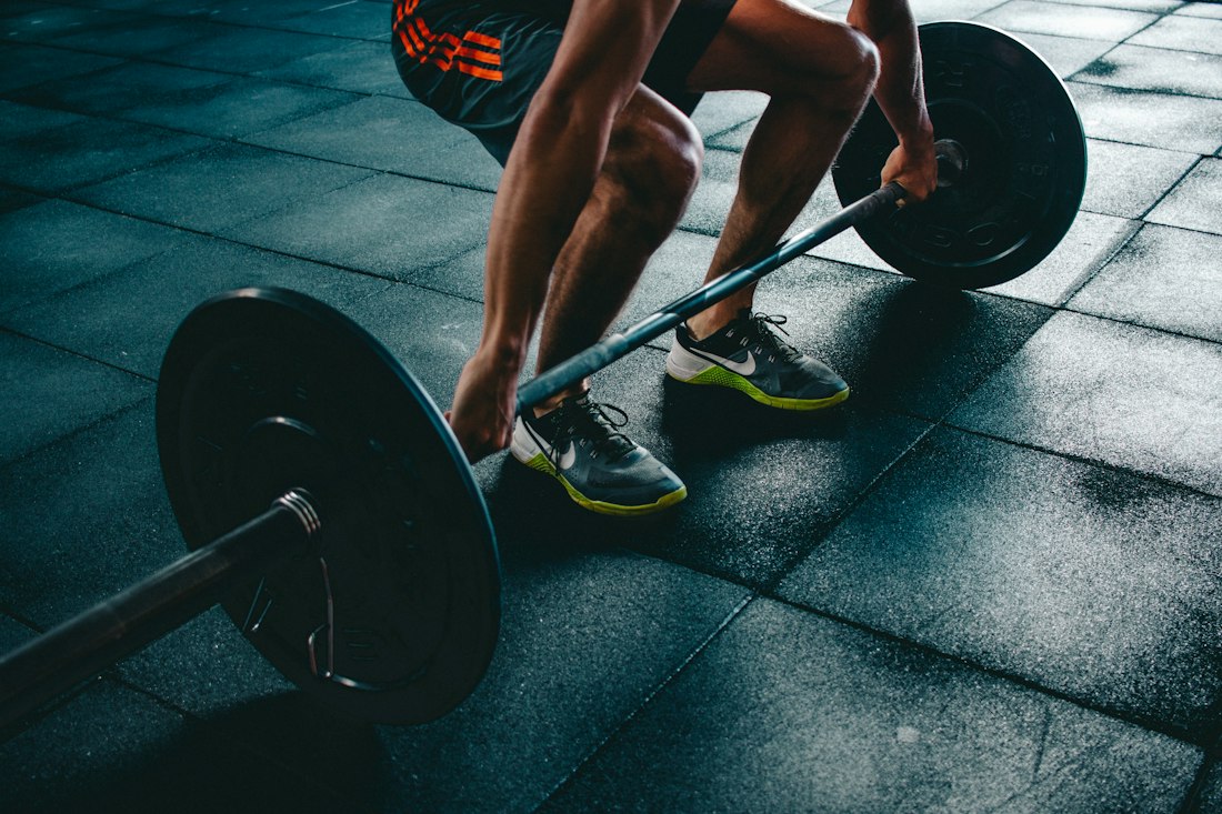 Deportista entrenando fuerza con una barra