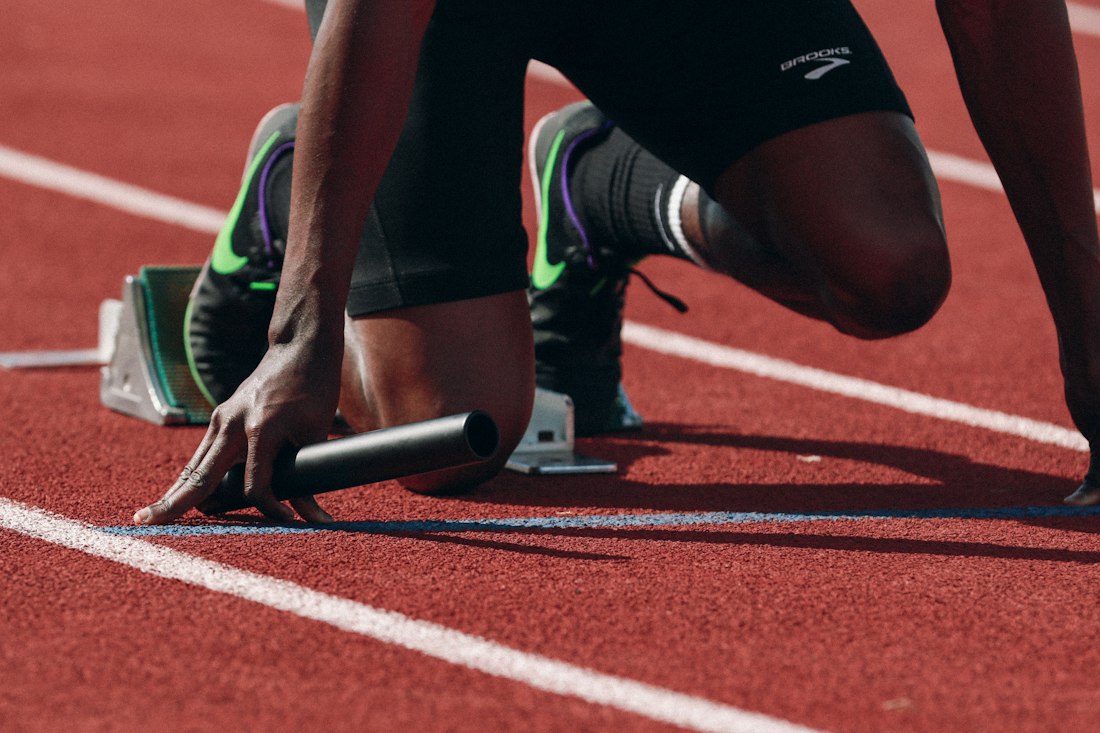 Atleta preparado para salir de los tacos en una pista